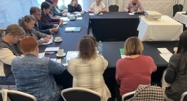 Uczestnicy spotkania zebrani przy stole w jasnej sali konferencyjnej.