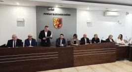 Uczestnicy spotkania przy stole, z jedną osobą przemawiającą