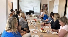 Uczestnicy przy stole podczas wykładu