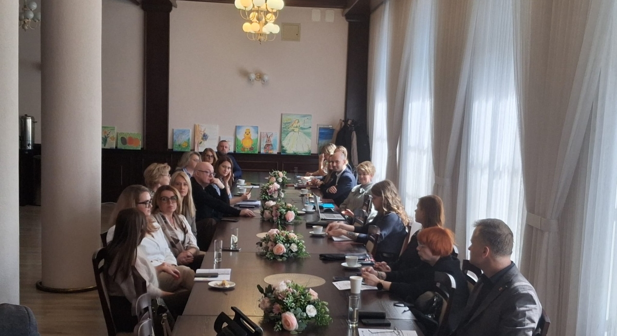 grupa-ludzi-siedzi-przy-dlugim-1777547331.jpg
